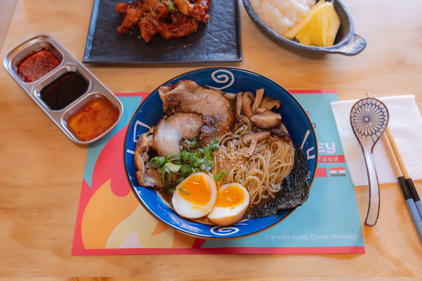 Mesa MONKEY con Tonkotsu Ramen, Korean Fire Chicken, Mango Sticky Rice y salsas